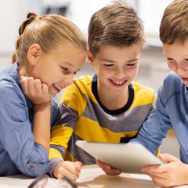 education, science, technology, children and people concept - group of happy kids or students with tablet pc computer programming electric toys and building robots at robotics school lesson
